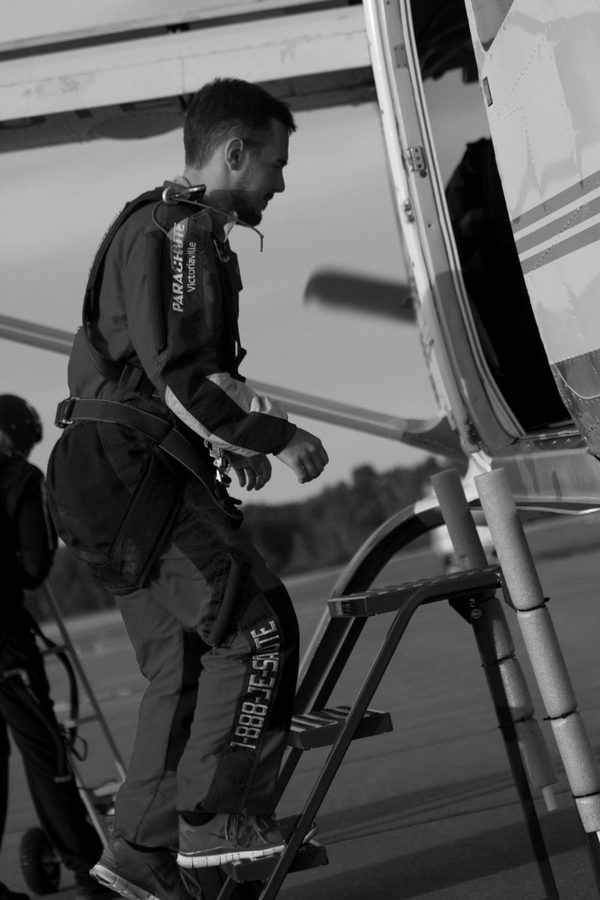 Maël Houck en combinaison de parachutisme monte à bord de l’avion.